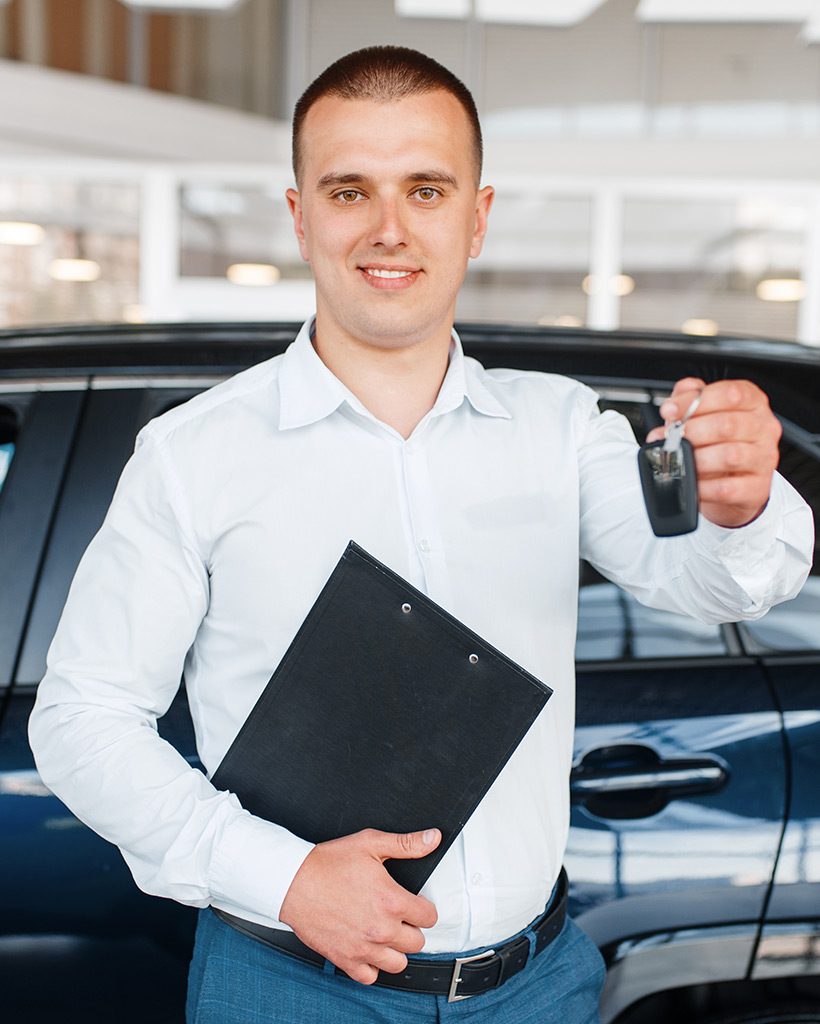 salesman gives key to the new car in showroom 4N2STYA