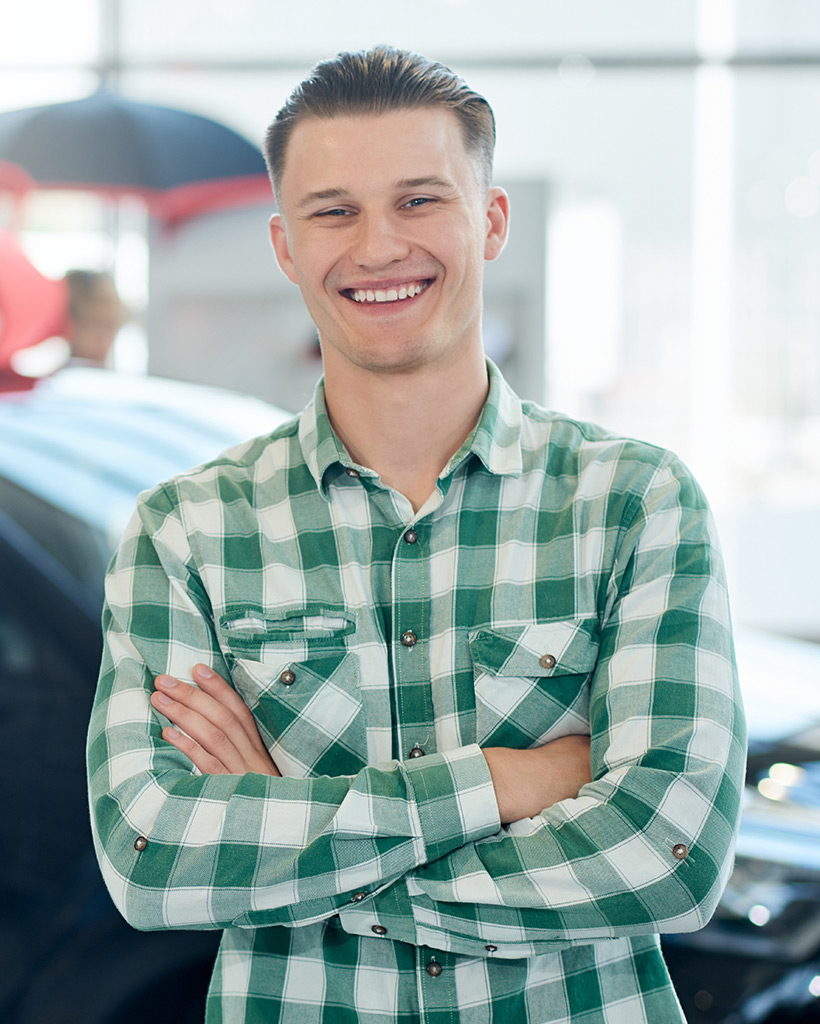 smiling man posing near car with arms crossed X84QFM5