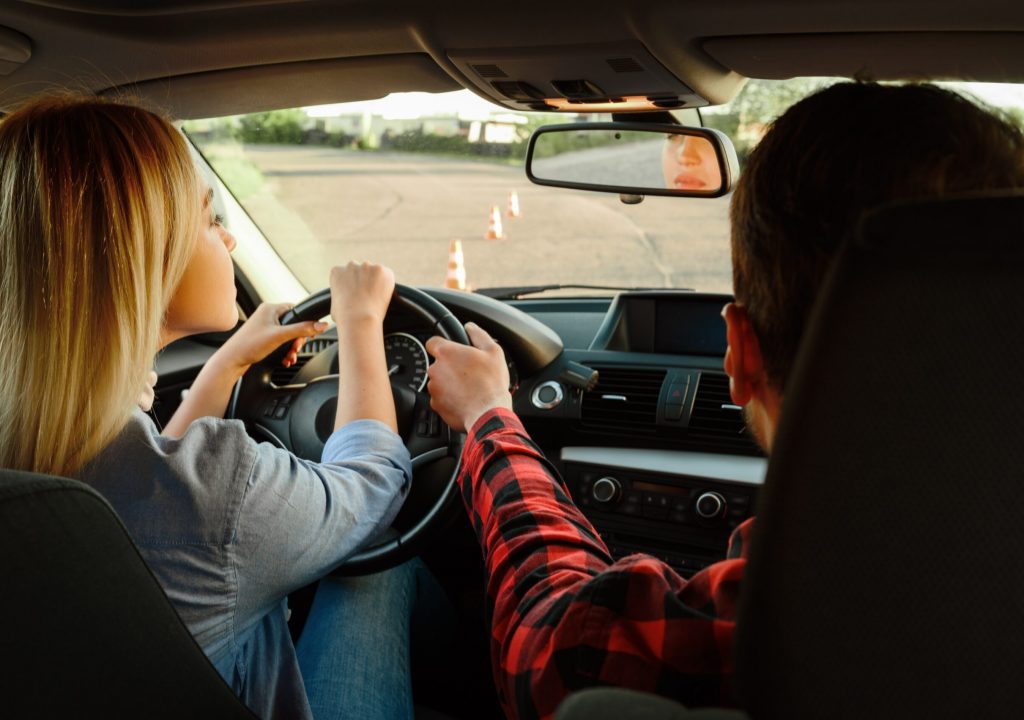 instructor helps woman to drive the car 2021 08 28 20 00 46 utc min scaled