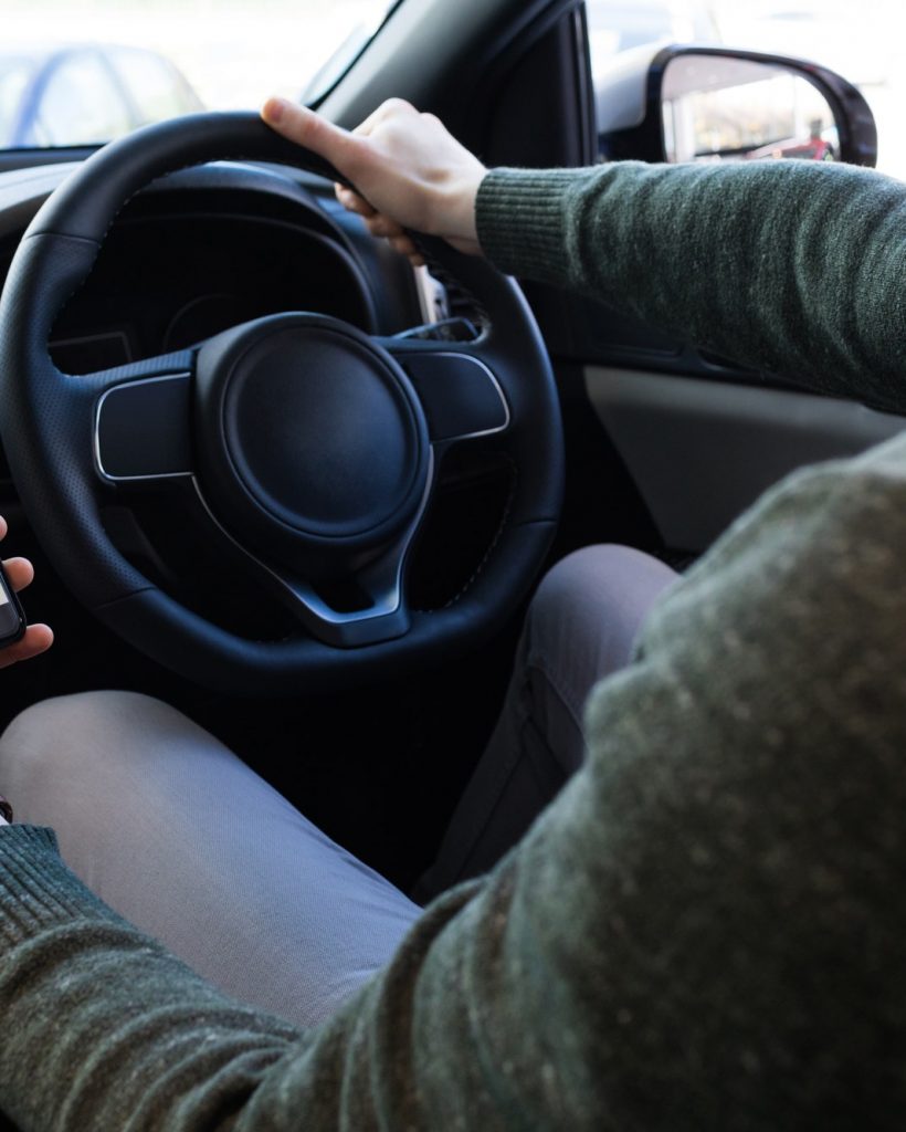 man using smartphone while driving car